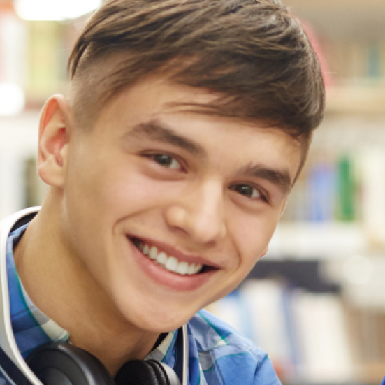 Billede af to smilende skoleelever, en dreng og en pige, der kigger ind i kameraet.