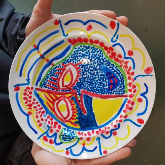 Barn holder en malet porcelænstallerken