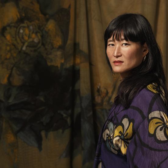 Forfatteringen Eva Tind stående i en lilla kimono.