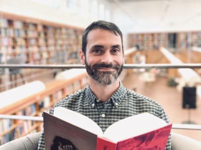 Litteraturformidler Benoit Enguerran Petit sidder i stol og læser bogen 'Sult'