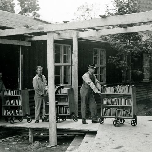 Biblioteksbetjente flytter bøger fra den gamle barak til den nye biblioteksbygning.