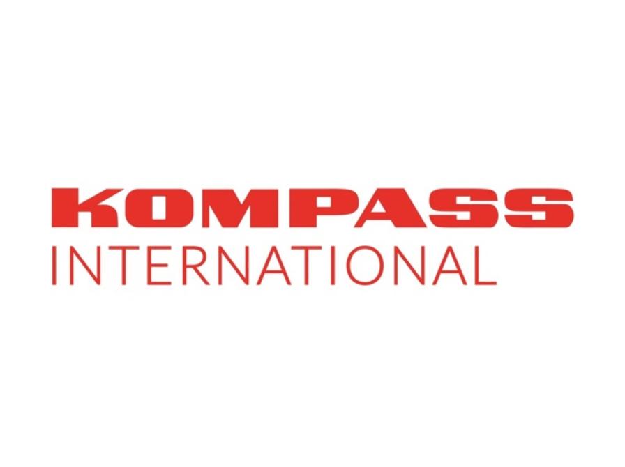 Logo for Kompass International med rød tekst på hvid baggrund.